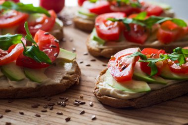 Ahşap masada avokado ve domates ile taze tost 