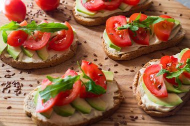 Ahşap masada avokado ve domates ile taze tost 