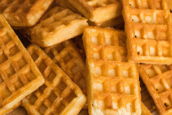 close up of many Belgian waffles on the wooden table 