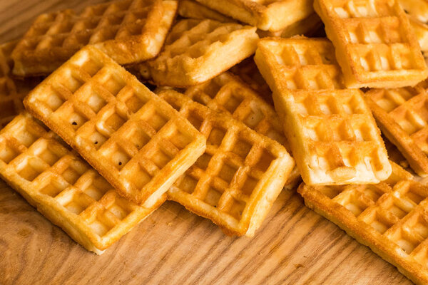 close up of many Belgian waffles on the wooden table 
