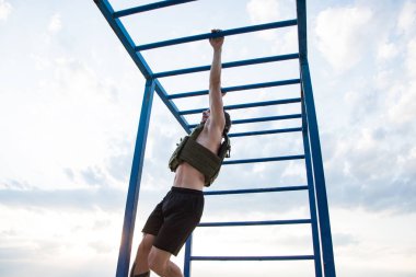 Genç sakallı atlet ağırlıklı yelek ile açık havada eğitim, askeri plaka taşıyıcı ile egzersiz