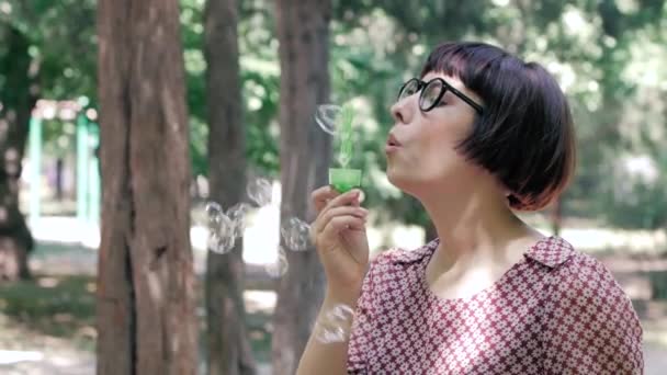 Jeune Femme Dans Des Lunettes Soufflant Des Bulles Extérieur Dans — Video