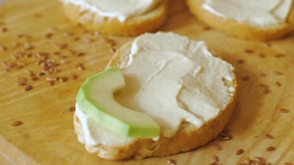 Färska Rostat Bröd Med Avokado Och Tomater Träbord — Stockvideo