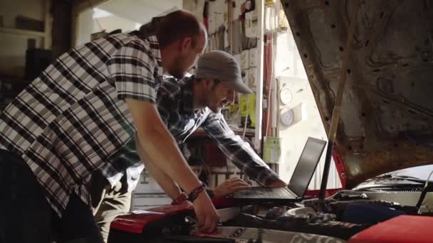 两名机械师在车库修理汽车发动机在工作间 — 图库视频影像