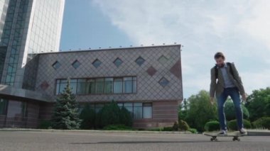 Genç sakallı erkek işadamı kaykay açık havada binmek