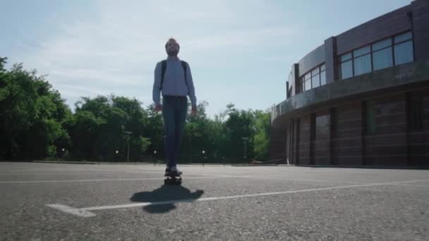 屋外のスケートボードに乗る若いひげの男性ビジネスマン — ストック動画