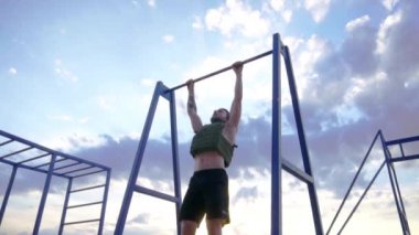 Genç sakallı atlet ağırlıklı yelek ile açık havada eğitim, askeri plaka taşıyıcı ile egzersiz