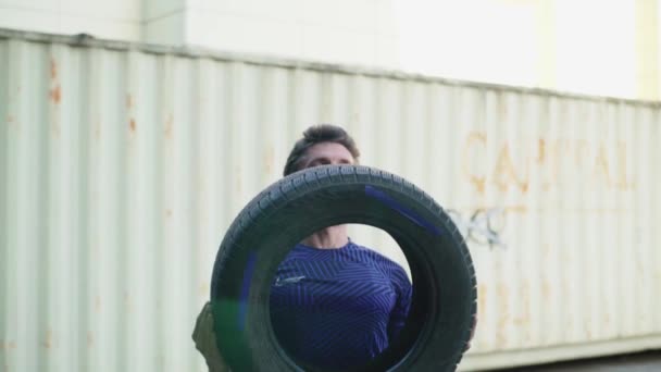 Young Bearded Male Exercises Car Tire Outdoors Industrial Urban Background — Stock Video