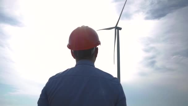 头戴头盔的男性工人在风力涡轮机上观看 — 图库视频影像