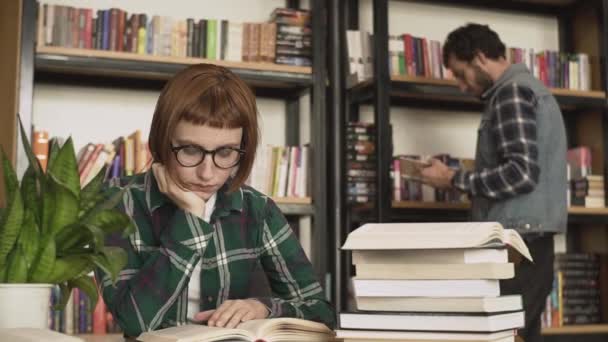 Young Redhead Woman Glasses Read Book Library — Stock Video