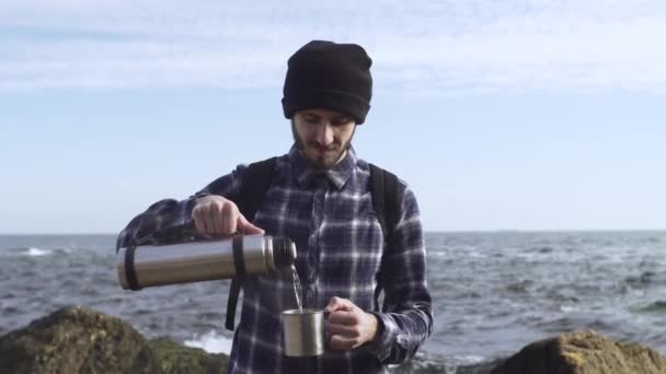 秋のビーチでリラックスバックパックを持つ若い男性旅行者 — ストック動画