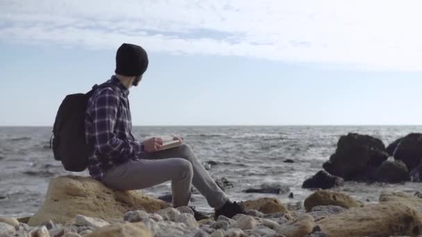 秋のビーチでリラックスバックパックを持つ若い男性旅行者 — ストック動画