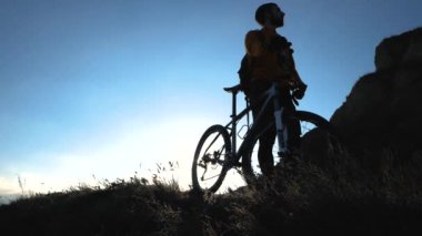 Genç erkek bisiklet binici yaz güneşli bir günde tepelerde seyahat