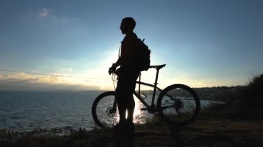 Genç erkek bisiklet binici yaz güneşli bir günde tepelerde seyahat