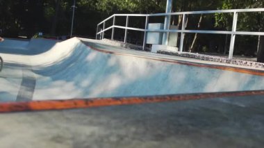 Beton kayak parkında erkek bisikleti sürüyor. 