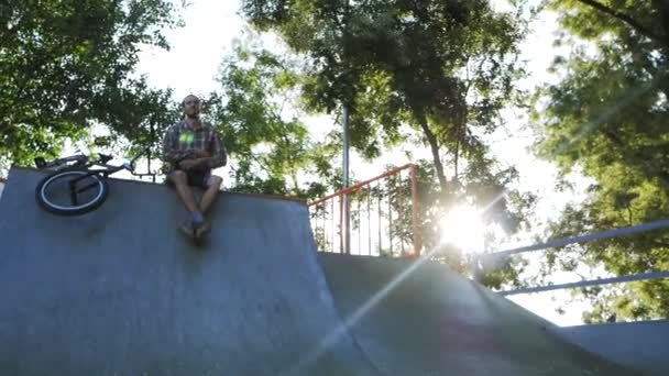 男子在混凝土滑板公园外面骑Bmx自行车 — 图库视频影像