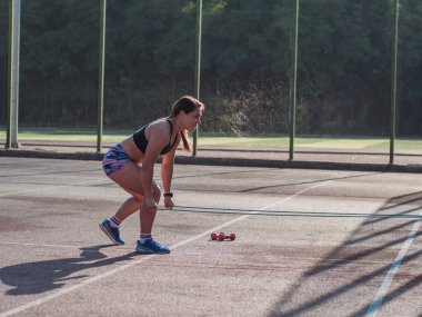 Genç ve güçlü bir kadın yazın dışarıda antrenman yapıyor, profesyonel bayan sporcu parkta egzersiz yapıyor.