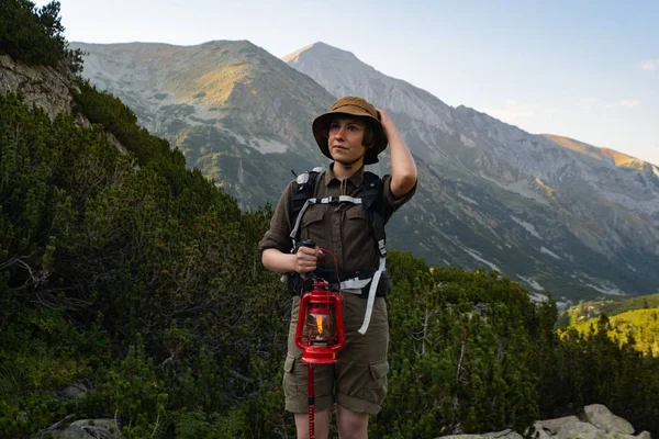 年轻快乐的女子背着背包和煤气灯站在美丽的群山中 — 图库照片