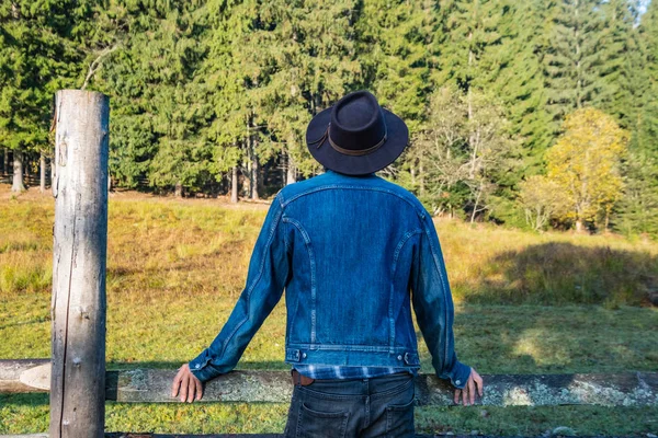Kot Ceketli Kovboy Şapkalı Genç Bir Çiftçi Ormanın Karşısındaki Ahşap — Stok fotoğraf
