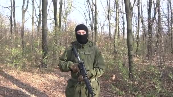 Soldado Uniforme Verde Máscara Preta Com Rifle Assalto Caminhando Floresta — Vídeo de Stock