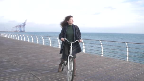 年轻健壮的嬉皮士女子骑着复古自行车在秋冬沙滩上摆姿势 — 图库视频影像