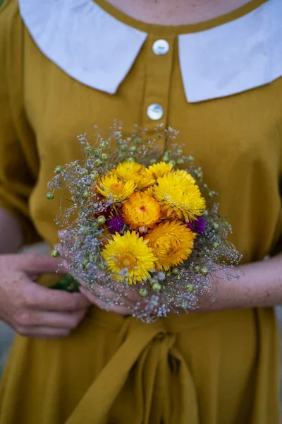 Young redhead woman with  freckles in vintage handmade dress walk in fields with flowers