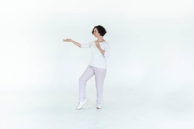 Beyaz stüdyo geleneksel Çin jimnastik salonunda qi qong antrenmanı yapan kadın.