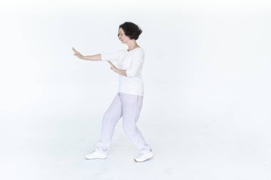 Beyaz stüdyo geleneksel Çin jimnastik salonunda qi qong antrenmanı yapan kadın.