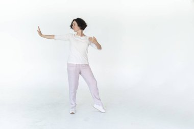Beyaz stüdyo geleneksel Çin jimnastik salonunda qi qong antrenmanı yapan kadın.