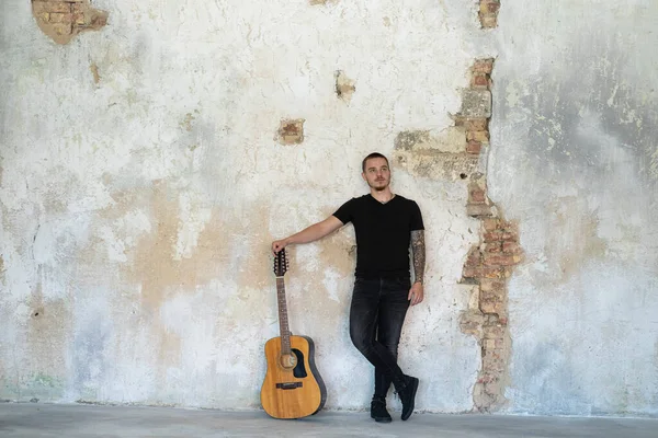 Junger Mann Mit Gitarre Leeren Raum Musiker Und Songwriter Allein lizenzfreie Stockfotos