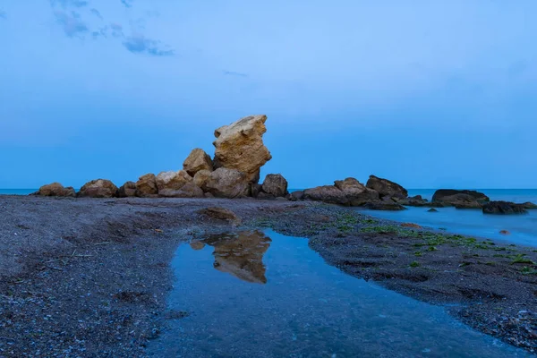 Landscape with sea, river and stones after sunset