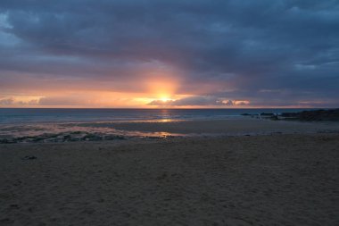 Fistral Beach, Newquay - günbatımı ile uzaktan Paddleboarders