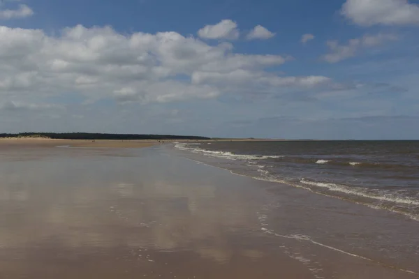 Мягкие облака отражаются на мокром песке в Уэллсе-за-морем — стоковое фото