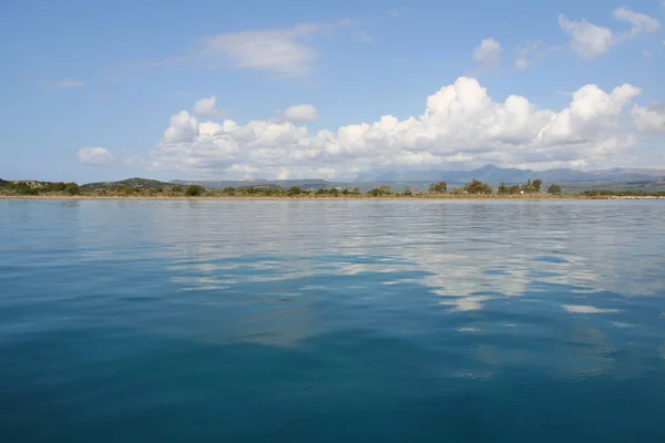 Güzel mavi Akdeniz Gialova, Yunanistan yansıtan bulutlar ile