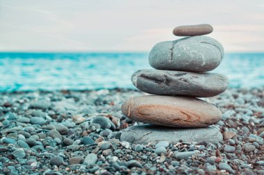 Çakıl taşları'nın deniz kıyısında kule. Zen ve denge sembolü