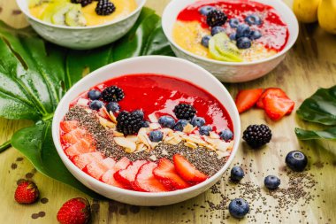 Güler yüzlü kase karışım monstera tropikal zemin üzerine bırakır, meyve ve çilek. Düz yatıyordu stili