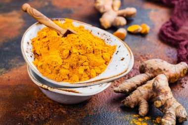 Zerdeçal tozu ve grunge arka plan üzerinde taze kök