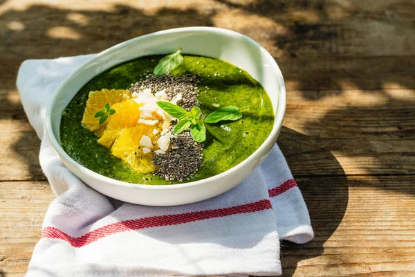 Tigela de smoothie verde com banana, espinafre, sementes de chia e laranjas — Fotografia de Stock