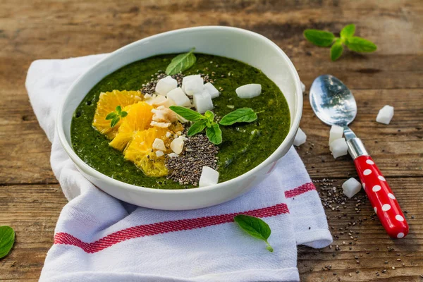 Tigela de smoothie verde com banana, espinafre, sementes de chia e laranjas — Fotografia de Stock