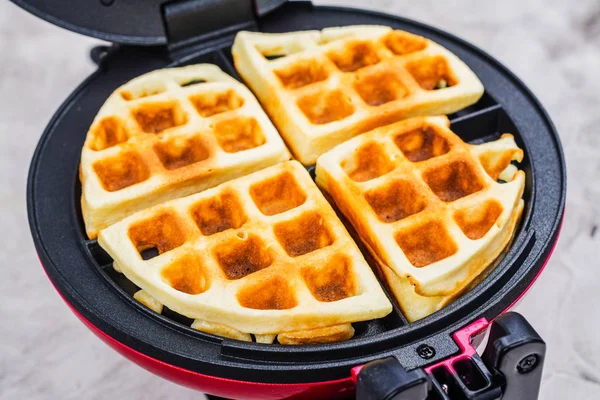 Waffles in an iron waffle maker — Stock Photo, Image