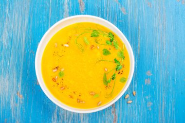 Mavi ahşap masa üzerinde balkabağı çorbası