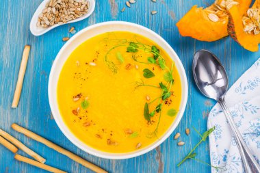 Mavi ahşap masa üzerinde balkabağı çorbası