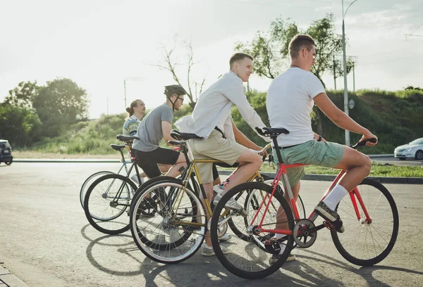 Group of cyclists starting riding fixed gear bikes on the road