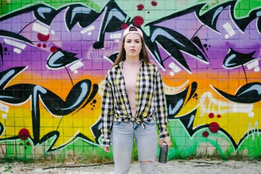 Genç kadın grafiti sanatçısı aerosol püskürtülen ilaç şişe duvarın yanında ile