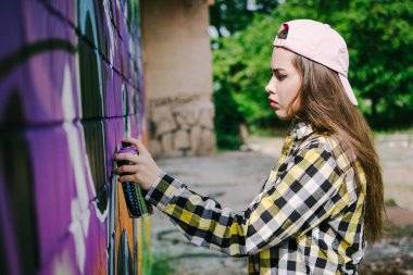 Genç kadın grafiti sanatçısı duvardaki açık çizim