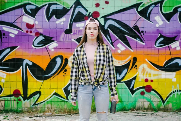 Genç kadın grafiti sanatçısı aerosol püskürtülen ilaç şişe duvarın yanında ile
