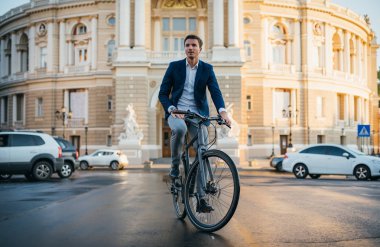 Yakışıklı genç adam sokakta şehir merkezinde onun bisikletle 