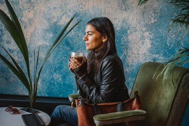 Sıcak cappuccino ile kafede oturan genç güzel kadın