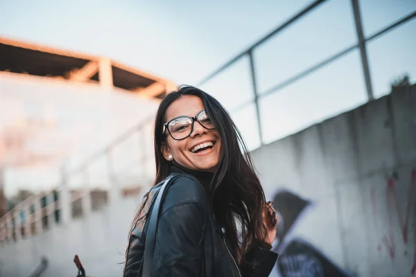 街背景に笑顔のメガネの若い美しい女性 — ストック写真