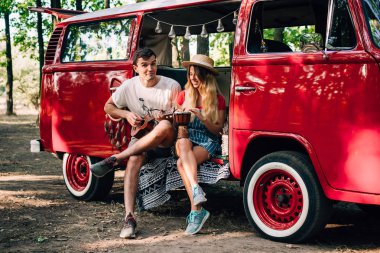 Otobüste oturuyor ve ukulele ve davul çalmaya genç hippi çift